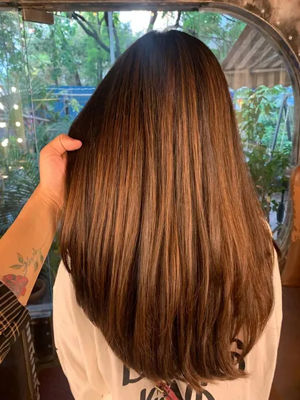 This rusty auburn look on straight hair shows how color can transform even without waves. The non-bleach formula gives it a sleek, high-shine finish.