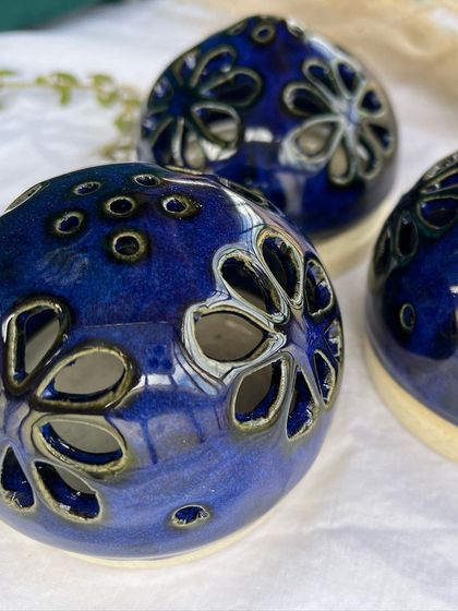 A closer look at the details of the blue tea light holders. The light shines through the carved flowers and small dots beautifully.