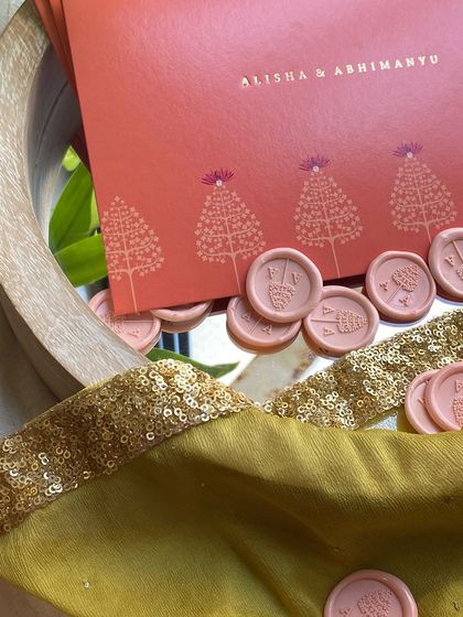 The magic of pearl-finish paper combined with subtle gold stamping and custom wax seals. This invitation for Alisha and Abhimanyu features a beautiful coral envelope and delicate tree motifs.