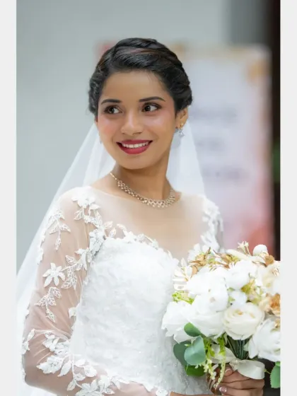 A radiant and happy bridal portrait. The bride's genuine smile and the beautiful details of her dress make this a perfect, classic shot.