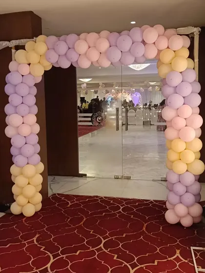 A pastel-colored balloon arch at the entrance of a baby shower event.