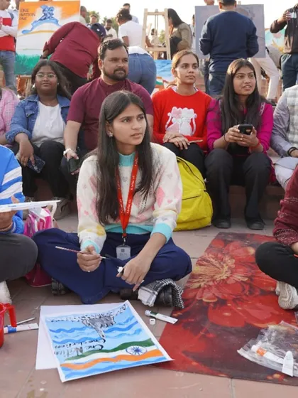 An engaged audience watches our students as they paint at the Central Park event. Public demonstrations are a key part of building artist confidence and community connection.