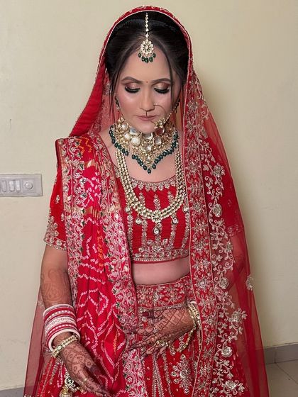 The complete look for this beautiful bride. Her makeup is kept clean and radiant, allowing her stunning red outfit and jewelry to shine.