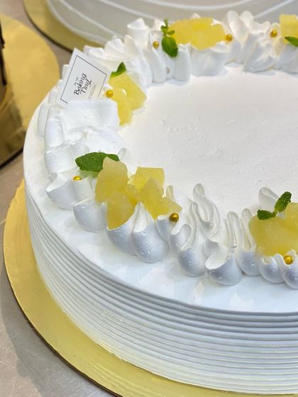 A close-up of the fresh pineapple cake with light whipped cream frosting.