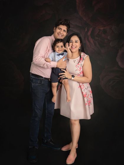 A happy family of three in coordinated pink outfits. Their joyful expressions and loving embrace make this a perfect family portrait.