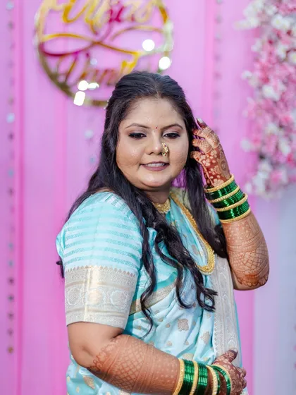 This portrait captures the client's joyful expression. The makeup highlights her features beautifully, including a traditional Maharashtrian nath (nose ring) that completes her engagement look.