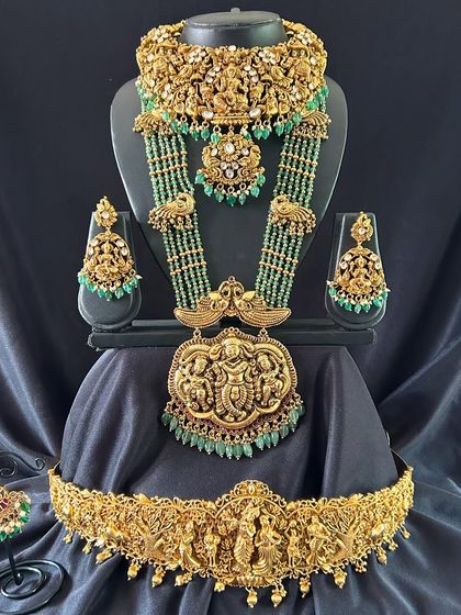 For a truly grand look, this set includes a choker along with the long haaram. The layers of antique gold and green beads create a stunning effect.