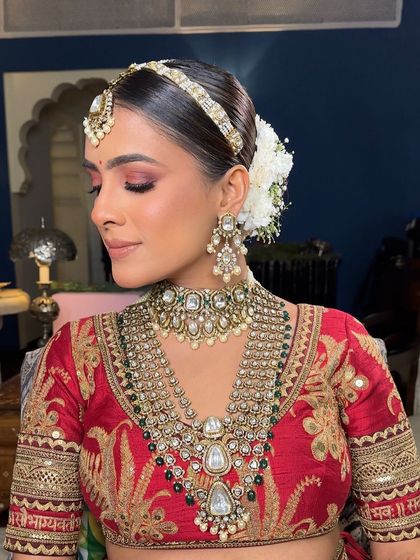 This Sabyasachi bride wanted a traditional yet clean look. I created a sleek center-parted bun wrapped in a classic white gajra, a timeless choice that exudes grace and sophistication for a wedding ceremony.