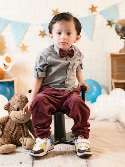 A dapper little man ready for his second birthday celebration. His serious expression and smart outfit make for a very handsome portrait.