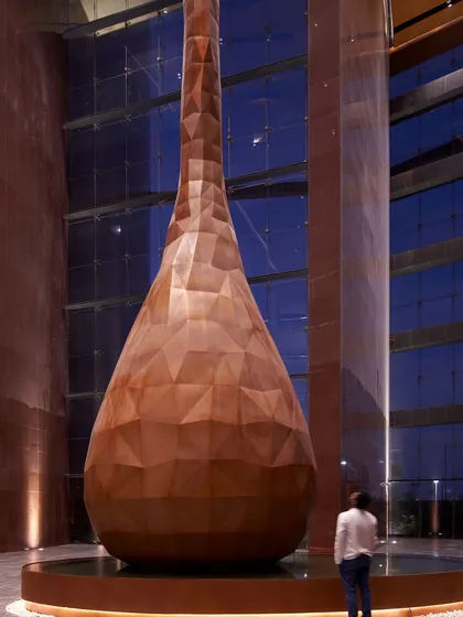 At the ceremonial entrance of the Surat Diamond Bourse, a 28-meter-high water droplet sculpture serves as a powerful focal point. Its faceted surface, inspired by diamonds, and the surrounding water feature create a sense of calm and reflect Surat's coastal identity.