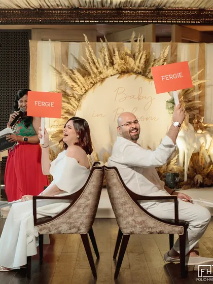 A snapshot from a chic and playful baby shower, where the parents-to-be are engaged in a fun game. This shows my expertise in planning all of life's milestones, with custom decor like the pampas grass wreath and personalized activities for guests.