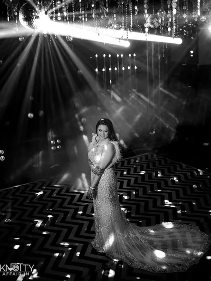 A stunning black and white portrait of the bride on the dance floor, illuminated by spotlights. We use lighting to create glamorous, star-like moments.