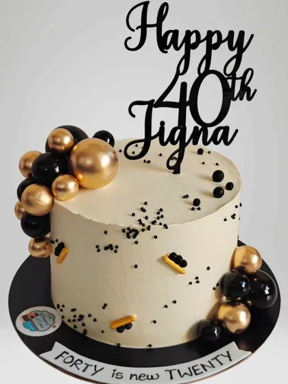 A chic black, white, and gold cake for a 40th birthday, because "forty is the new twenty". The balloon cascade adds a modern and festive touch.