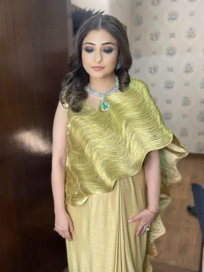 The full look is a picture of grace. The dark smokey eye provides a beautiful contrast to the shimmering gold outfit and sparkling diamond necklace.