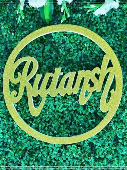 A close-up of the custom golden cutout for the name "Rutansh". These cutouts are a stylish way to display the baby's name.
