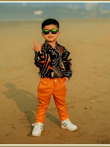Rocking his birthday look. We love creating outfits that are as unique as your child, like this combination of a bold patterned shirt and bright orange trousers for a fun, modern birthday style.