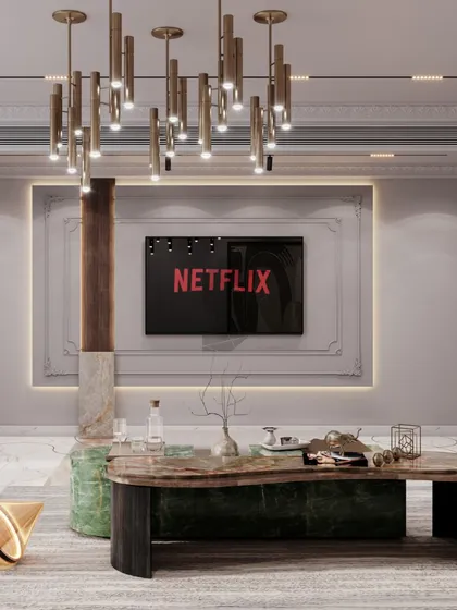 The entertainment unit in this neo-classical living room is framed by classic wall molding, seamlessly integrating modern technology into a timeless design. The organic-shaped coffee table and unique pillar detail add layers of visual interest to the space.