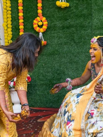 A playful moment between friends during the Haldi ceremony. We love capturing the fun and messy parts of the celebration.