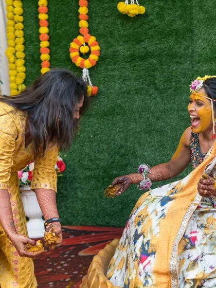 A playful Haldi moment between the bride and a friend.