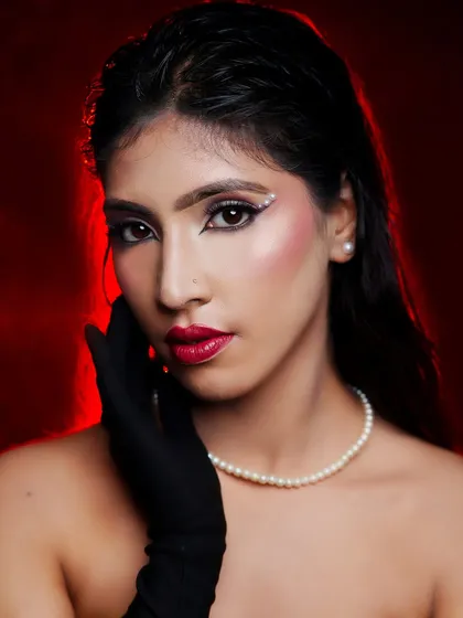 A classic vintage glam look with a pearl necklace, black gloves, and a sharp, pearl-accented winged eyeliner.