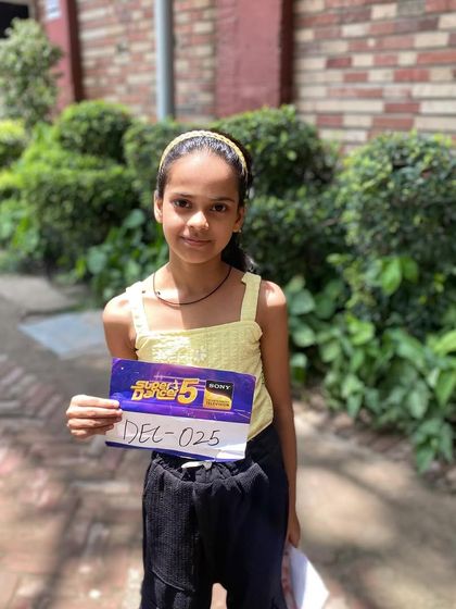 A close-up of our student holding her audition card for 'Super Dancer 5'. This represents a significant milestone in her journey as a competitive dancer.
