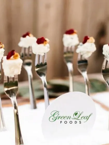 An elegant and simple appetizer. Cubes of soft cheese are placed on forks and topped with walnuts and dried fruit, offering a delightful combination of textures and flavors in a single bite.