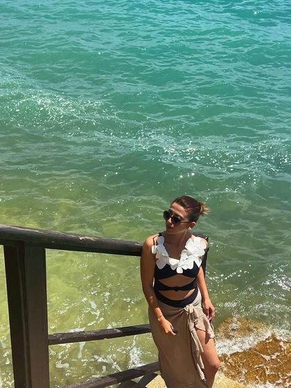 By the beautiful turquoise water. This black swimsuit with white floral appliqué is one of my more unique beachwear pieces.