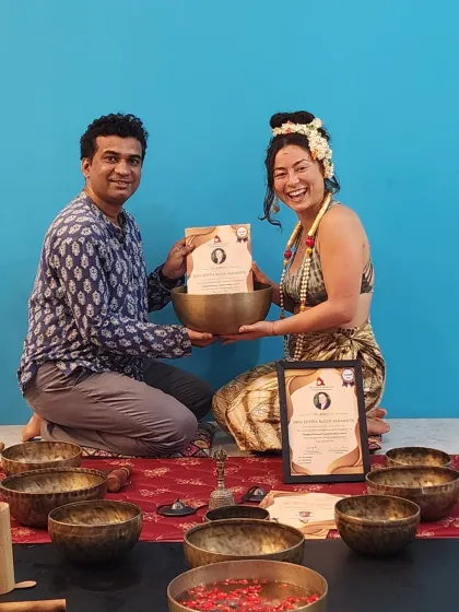 A proud moment, presenting a certificate to a graduate of the Sound Healing Teacher Training. She is surrounded by the tools of her new craft, including a large healing bowl.