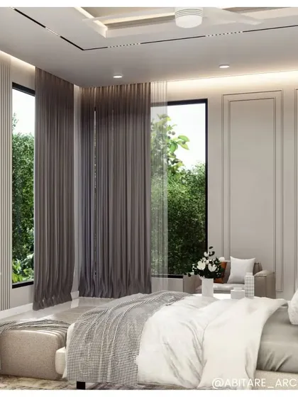 A view of a bedroom that showcases how natural light can be controlled to create a mood. Floor-to-ceiling windows are framed with heavy drapes, allowing the space to be either bright and airy or dark and cozy.