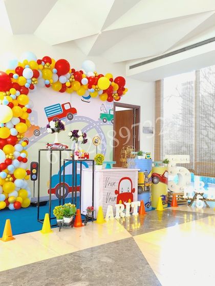 The full setup for the car and truck theme, showing the balloon arch, backdrop, and themed props creating a complete scene.