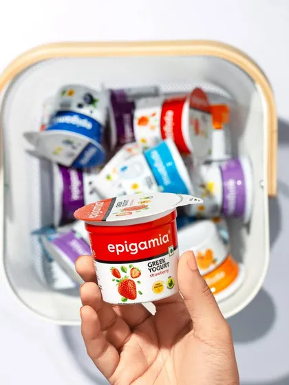 A simple and clean shot for Epigamia's Greek yogurt range. A hand holds one cup forward from a basket full of different flavors, conveying the idea of choice and everyday convenience.