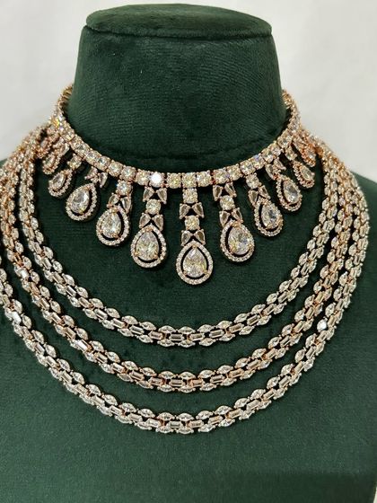 A full view of a multi-layered American diamond necklace set in a rose-gold finish. This rental piece is perfect for a modern bride.