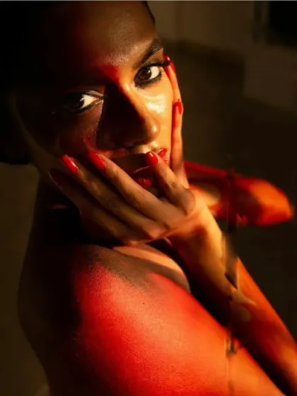 A close-up detail of the fire body paint, highlighting the brushwork and blending on the shoulder and face. The wet-look hair adds to the elemental feel of the character.