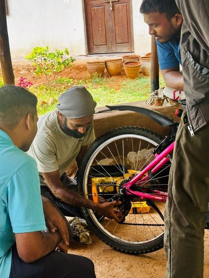 Mentors and participants work together on a bicycle at our Vanee Farms workshop. It's a great example of community members sharing their skills.