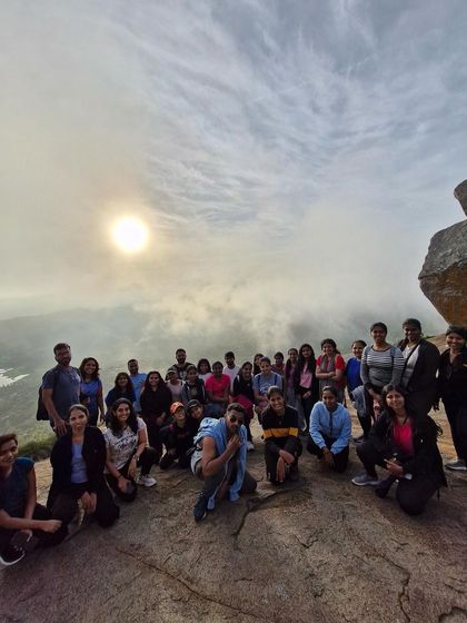 A fisheye view of our large group at the summit of Uttari Betta, with the sun rising through the clouds.