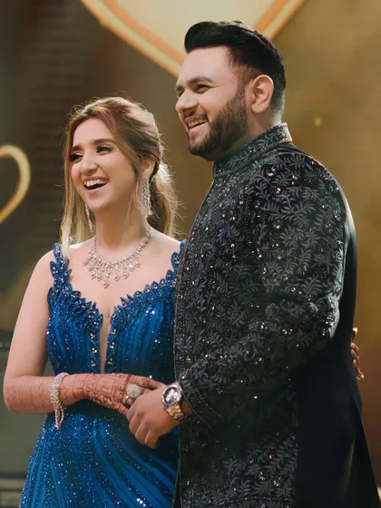The couple sharing a laugh on stage during their engagement. This candid photo is full of life and happiness, a perfect memory of their celebration.