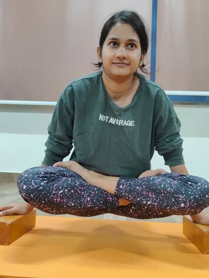 This student is practicing Lolasana on blocks. This is an excellent way to build the core compression and arm strength required to eventually lift the legs and body off the floor.