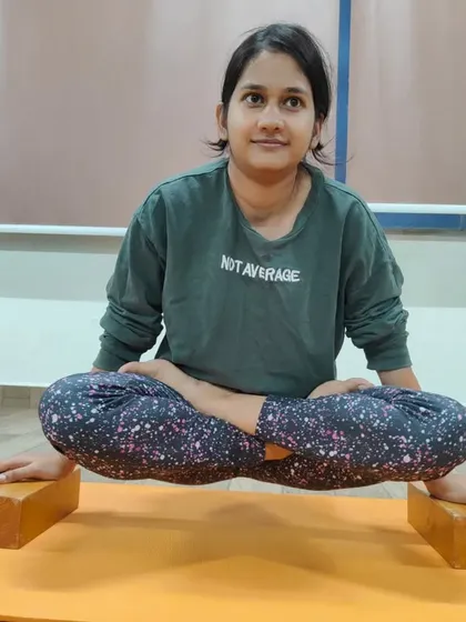 This student is practicing Lolasana on blocks. This is an excellent way to build the core compression and arm strength required to eventually lift the legs and body off the floor.