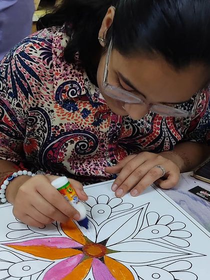 A student focused on creating her design during the Rangoli competition. These events are a great way to practice skills under a fun, timed challenge.