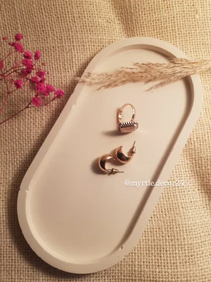 A top-down view of our white oval trinket tray, styled with pampas grass and delicate jewelry. It’s a simple piece that makes a big impact.