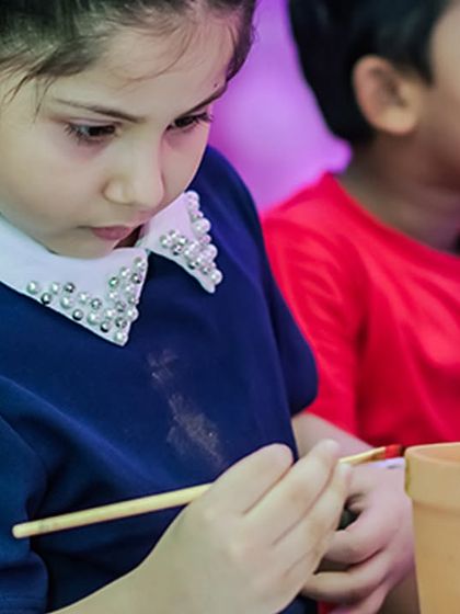 Another focused artist decorating a small pot. These activities are perfect for creating a calmer zone within a high-energy party.