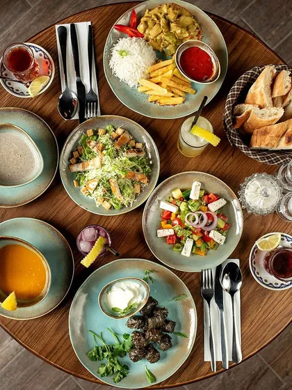 An overhead view of a table filled with a complete meal we catered. This spread showcases a variety of dishes, including salads, main courses with rice, fresh bread, and soups, representing a full and hearty dining experience.