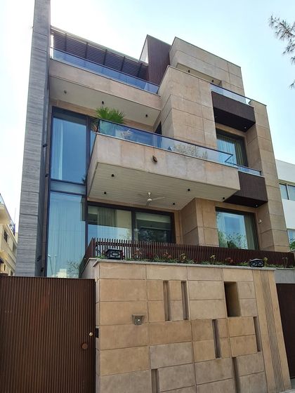 An architectural harmony of materials, where glass meets textured layers of stone and wood. The beige and brown tones create a calm yet captivating exterior, resulting in a home that is a masterclass in modern serenity.