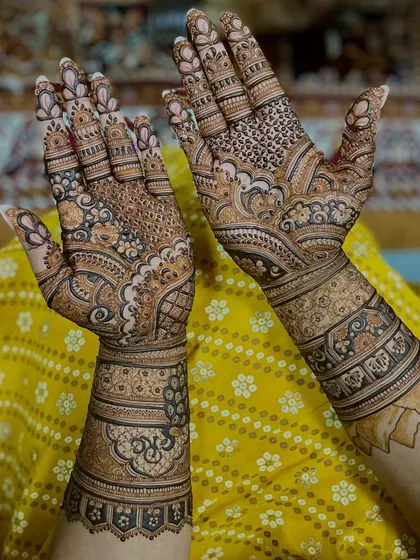 A minimal yet intricate bridal design featuring peacocks, lotuses, and wedding bells. It proves that bridal mehendi can be both light and full of detail.