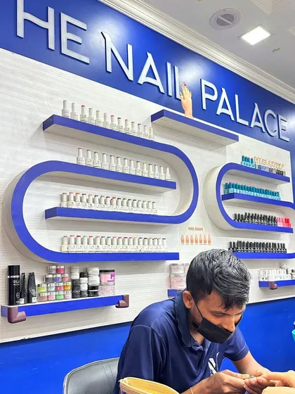 A shot of the salon in action. One of my expert technicians is focused on creating the perfect manicure for a client, surrounded by our extensive collection of polishes.