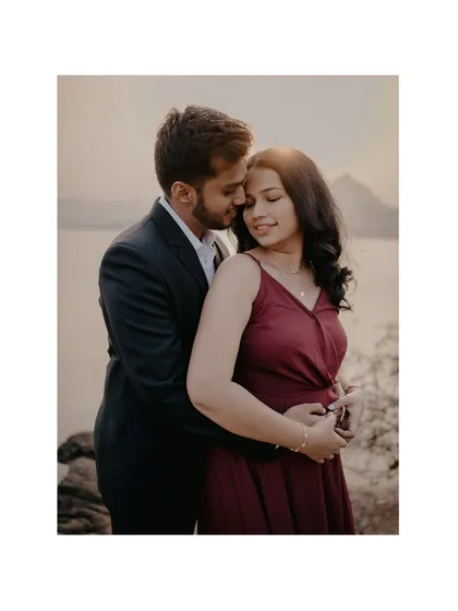 A classic, romantic portrait framed by a white border. The couple's close embrace and the beautiful lakeside setting make for a timeless and elegant pre-wedding photo.