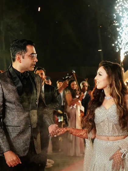 A look of love between the couple during their Sangeet entry. Amidst the pyrotechnics and cheering crowd, these small, intimate glances are the moments that truly define the celebration.