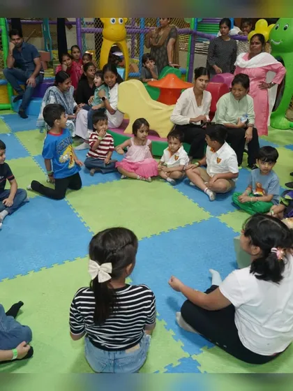 A group of children gathered for story time or a group game during a summer holiday visit.