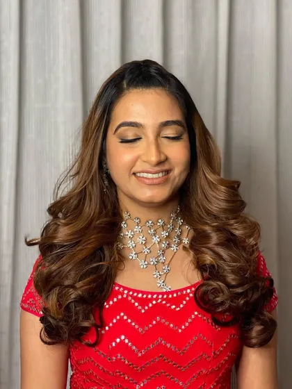 A happy smile from a client who feels amazing. The voluminous curls are the perfect party hairstyle.