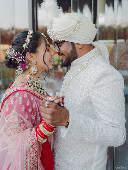 A tender moment between the bride and groom, lost in each other's eyes. This classic portrait showcases their beautiful wedding attire and the love they share.